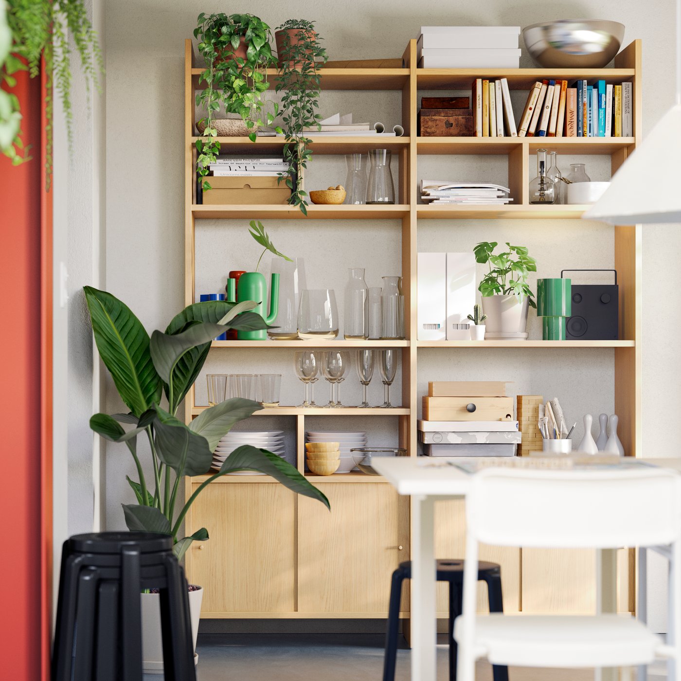 A LÅDMAKARE storage combination with sliding doors stores glasses, pots, and plants in a dining area with a table and chairs.