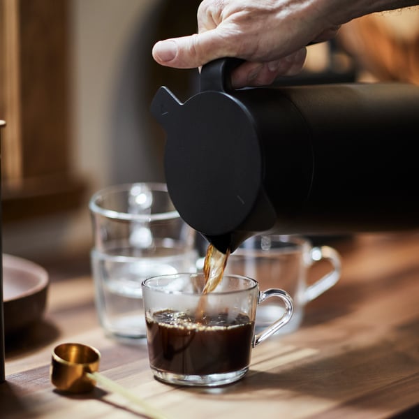 Una persona sirviendo café sobre un muy de vidrio de la serie IKEA 365+.