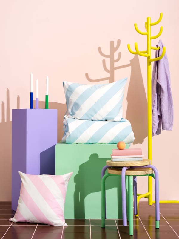 A selection of the pastel Nytillverkad products are arranged in an artful composition including the SLÖJSILJA duvet set.