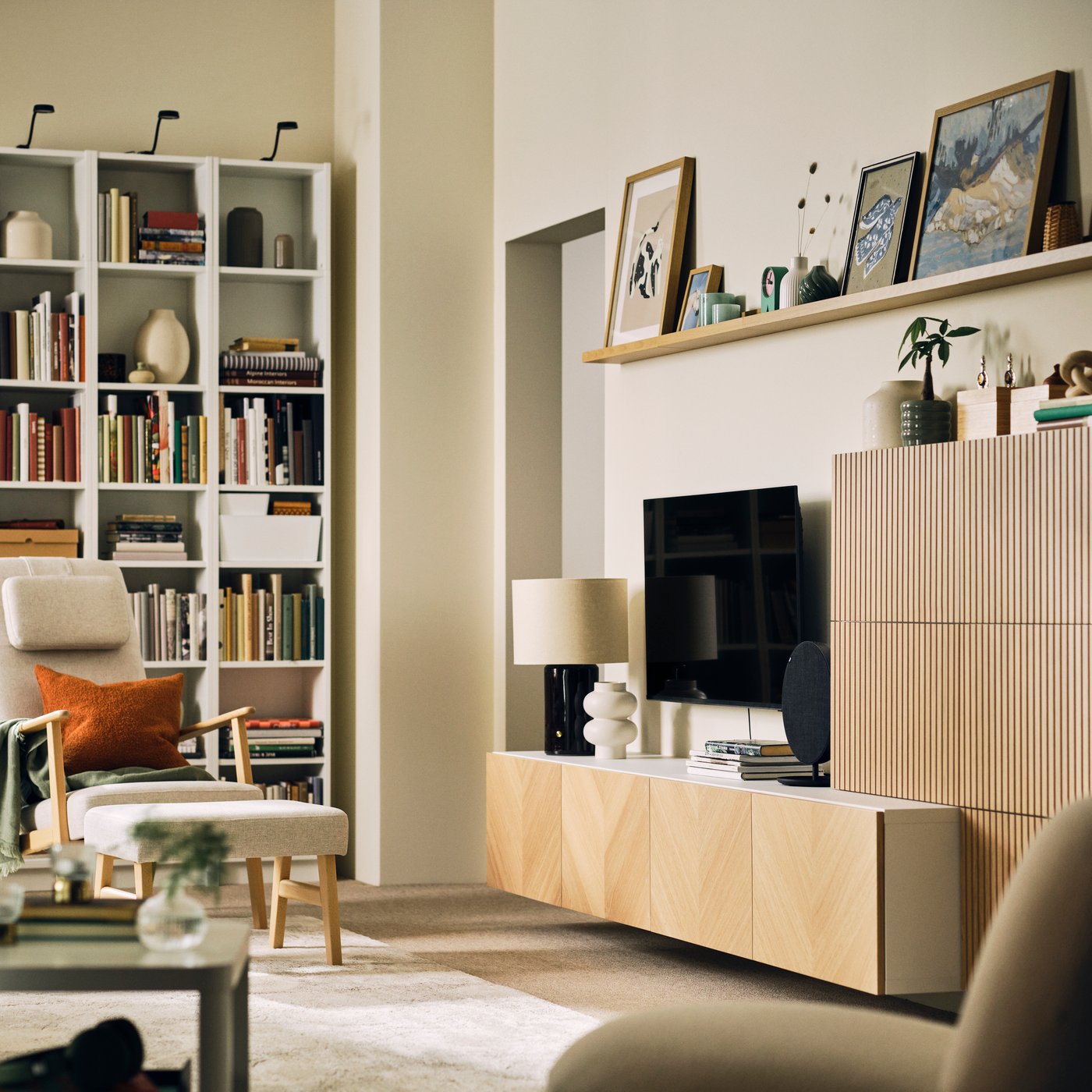 A neat, bright living room with a BESTÅ storage combination with oak-veneer fronts, bookshelves and an EKENÄSET armchair.