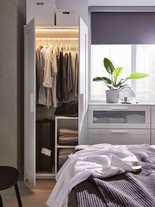 A light grey TRETUR block-out roller blind in the bedroom