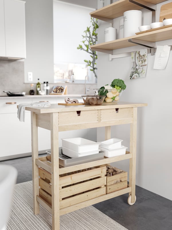 Un carrito de cocina de madera con cajas organizadoras.