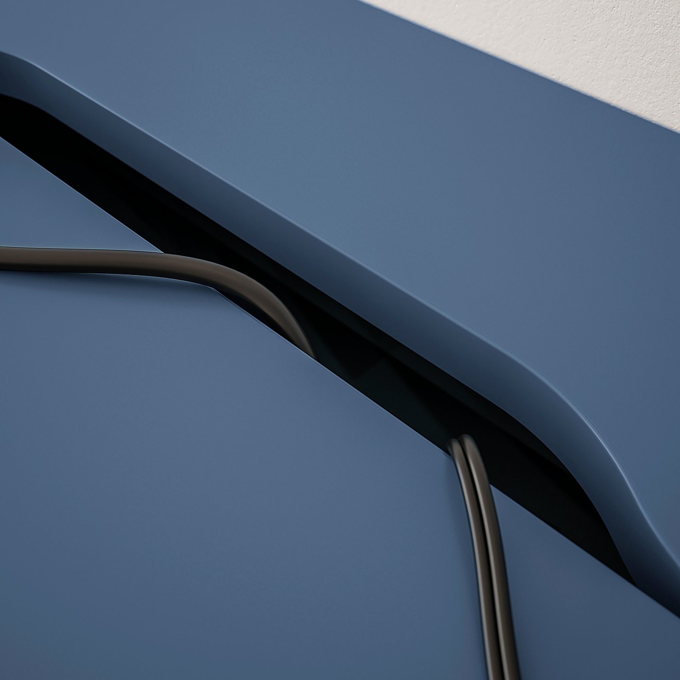 A close-up of cable management in a black-blue ALEX desk.