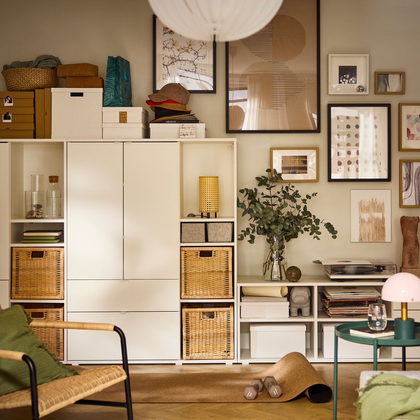 A living-room wall half-covered by a white VIHALS storage combination, the other half covered by a cluster of framed art.