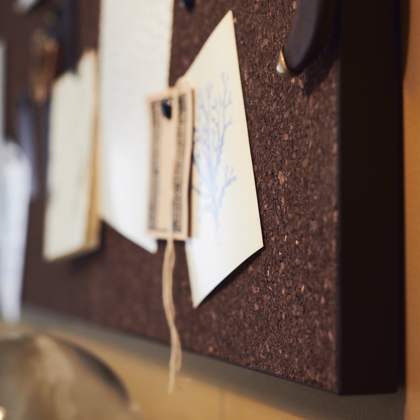 A SVENSÅS memo board in fibreboard and cork with various paper items attached to it.