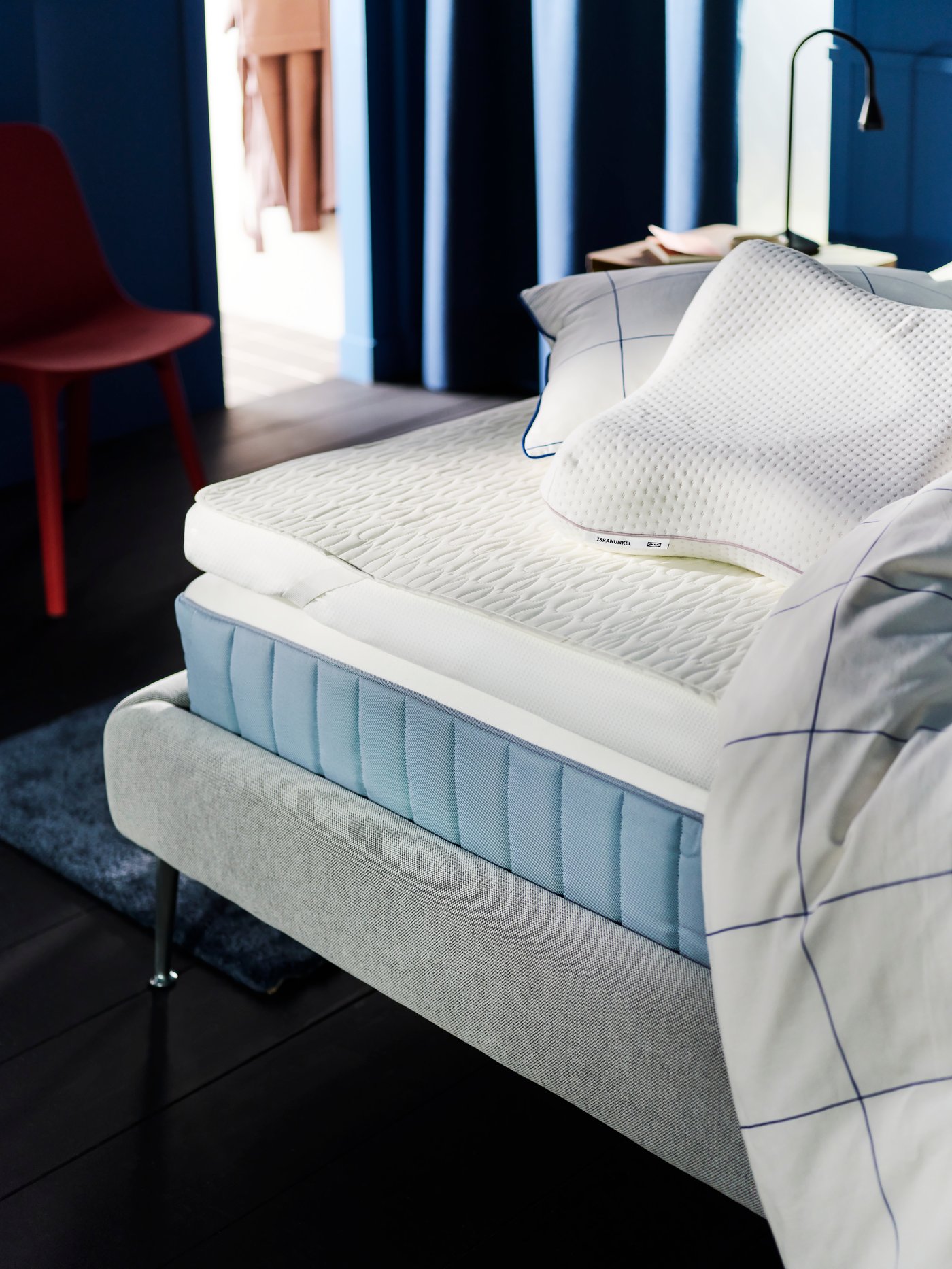 A VÅGSTRANDA mattress on a TUFJORD bed with a TUSSÖY mattress pad, pillows and a duvet in a BREDVECKLARE cover on top.