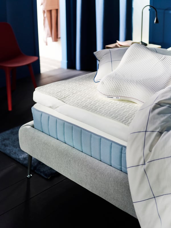 A VÅGSTRANDA mattress on a TUFJORD bed with a TUSSÖY mattress pad, pillows and a duvet in a BREDVECKLARE cover on top.