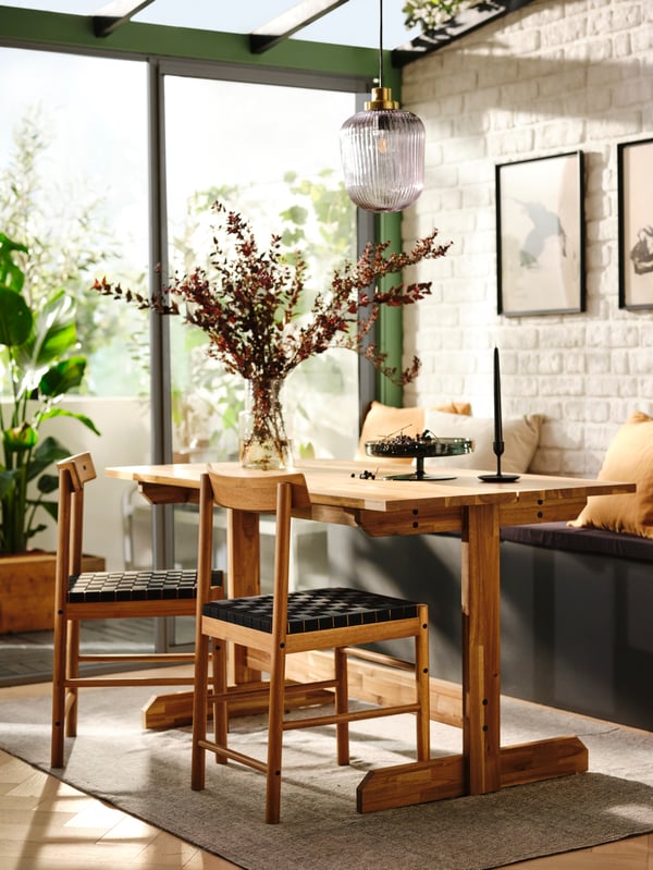 A beautiful dining room with lots of natural light featuring a NACKANÄS dining table accompanied by matching NACKANÄS chairs.