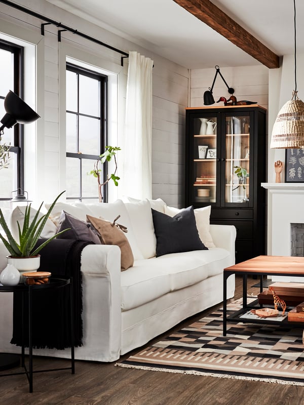 A white GRÖNLID 3-seat sofa in a traditional-style living room with a glass-door cabinet, patterned rug, and a coffee table.