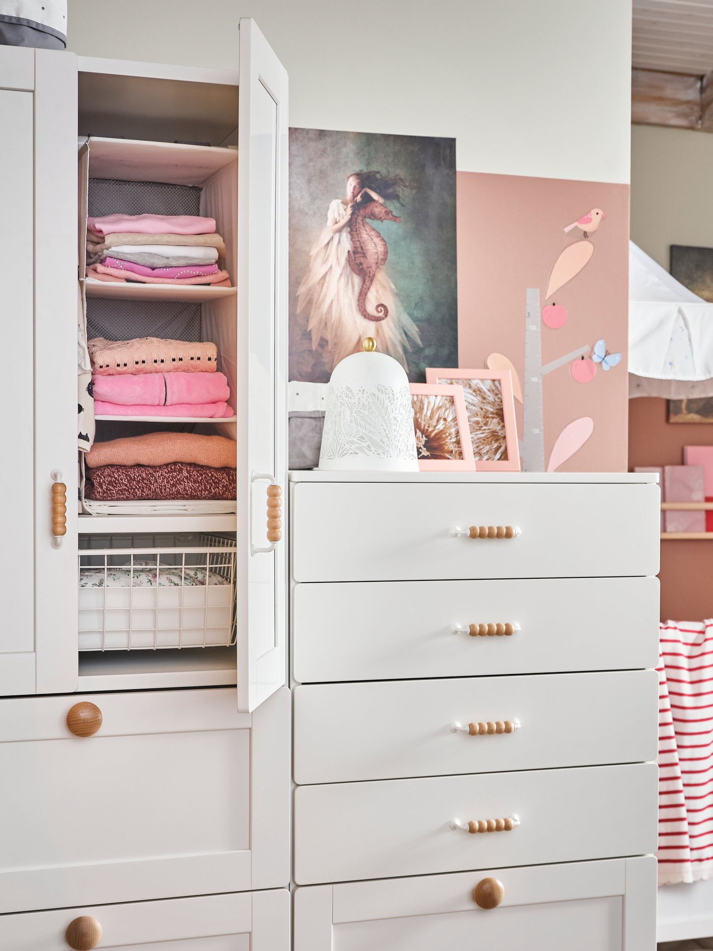 A SMÅSTAD wardrobe and chest of drawers. Inside the wardrobe is a RASSLA storage with 5 compartments holding clothes.