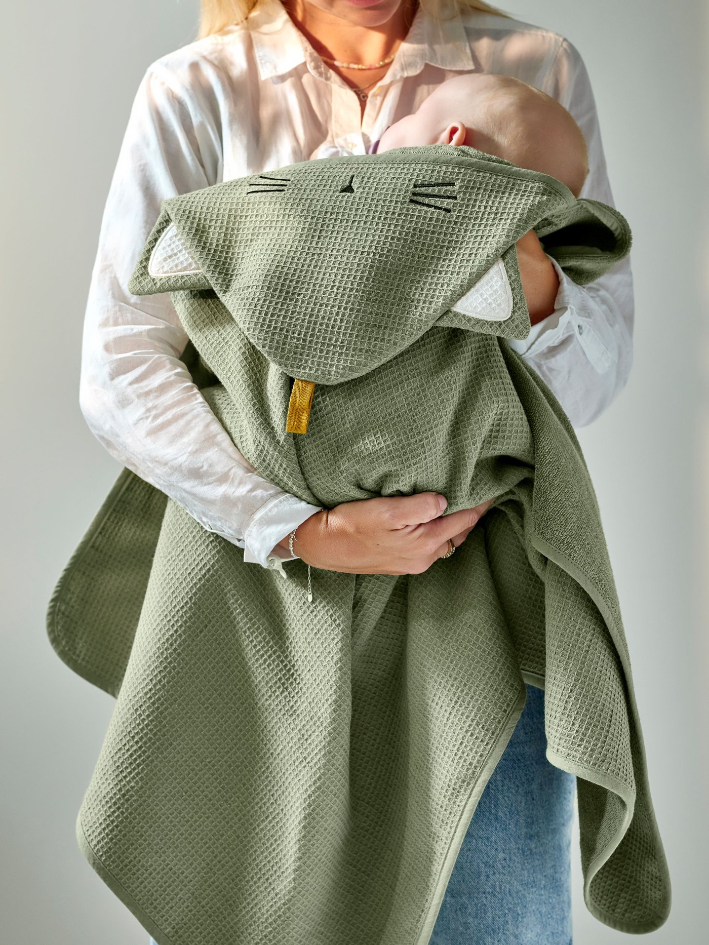 A green GULDVÄVARE baby towel with hood