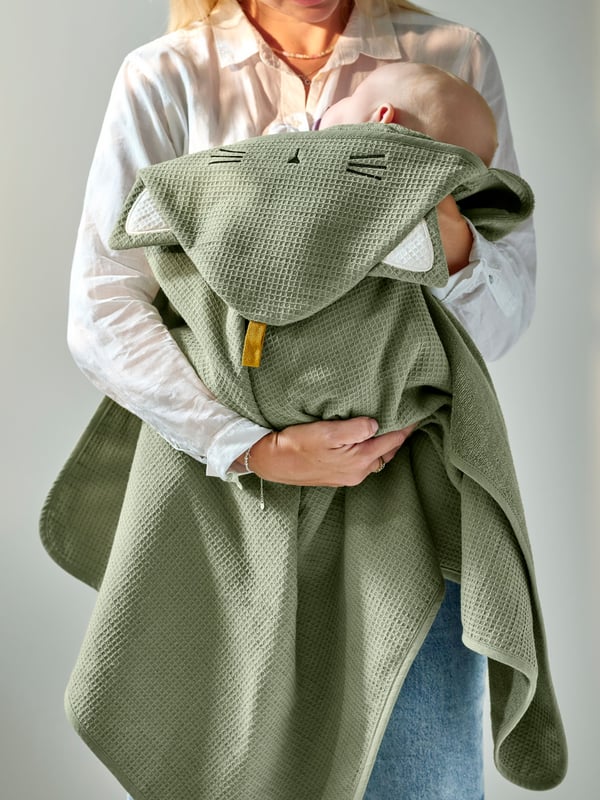 A green GULDVÄVARE baby towel with hood