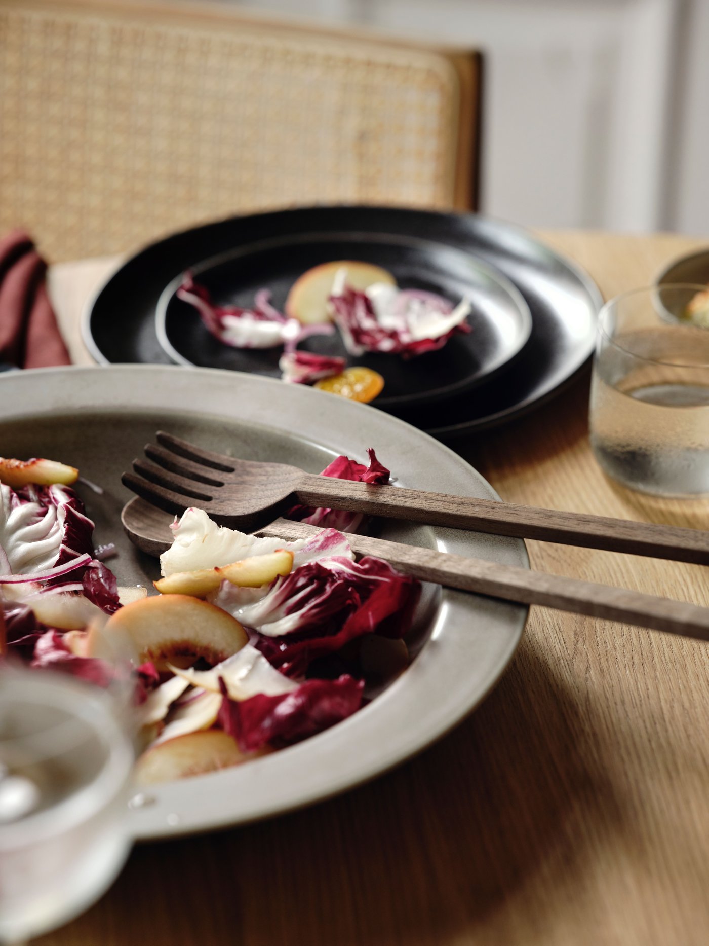 A beige STOCKHOLM 2025 serving bowl with a walnut STOCKHOLM 2025 serving set in the dining room.