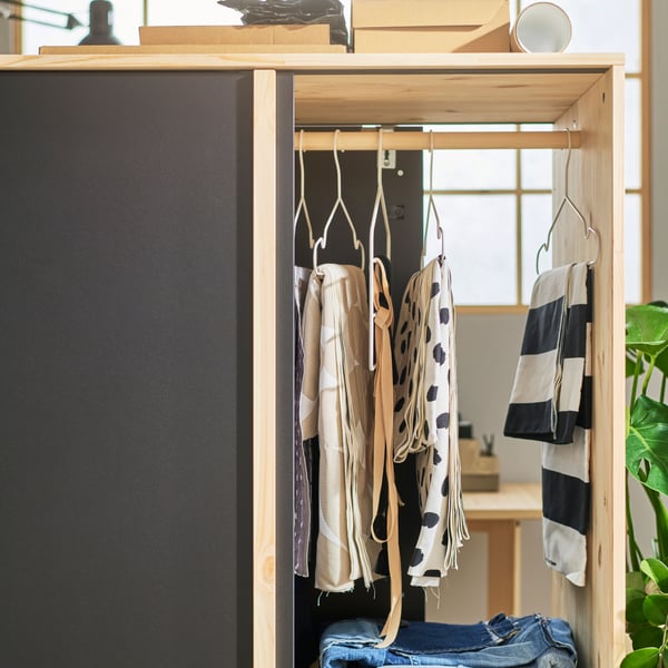 GLAMBERGET wardrobe shot from the side with sliding doors open from both sides, to show hanging and folded clothes inside.  