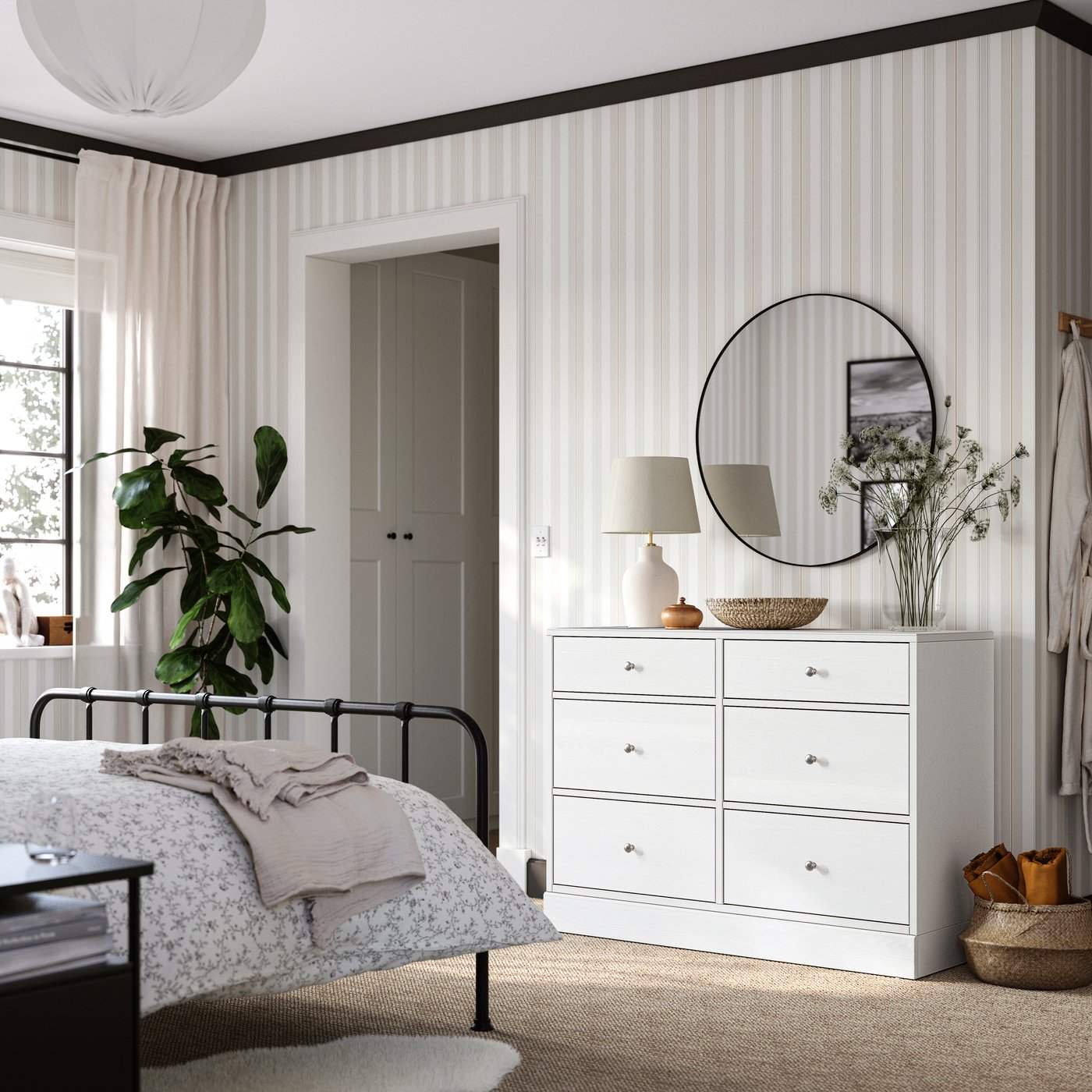 Bedroom with STJÄRNÖ bed frame, wallpaper in beige and white, a white HAVSTA chest of drawers with a round mirror above it.
