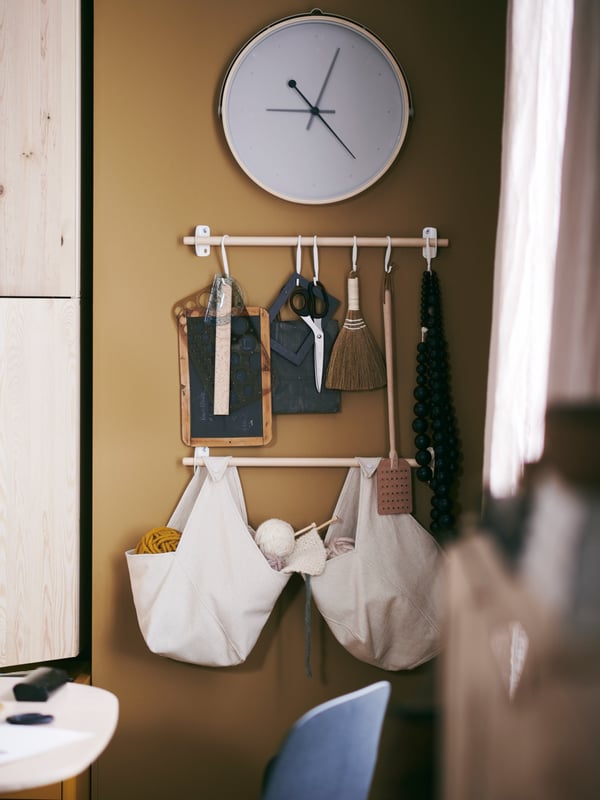 An assortment of storage products from the NEREBY series are mounted on the wall close to a dining table.