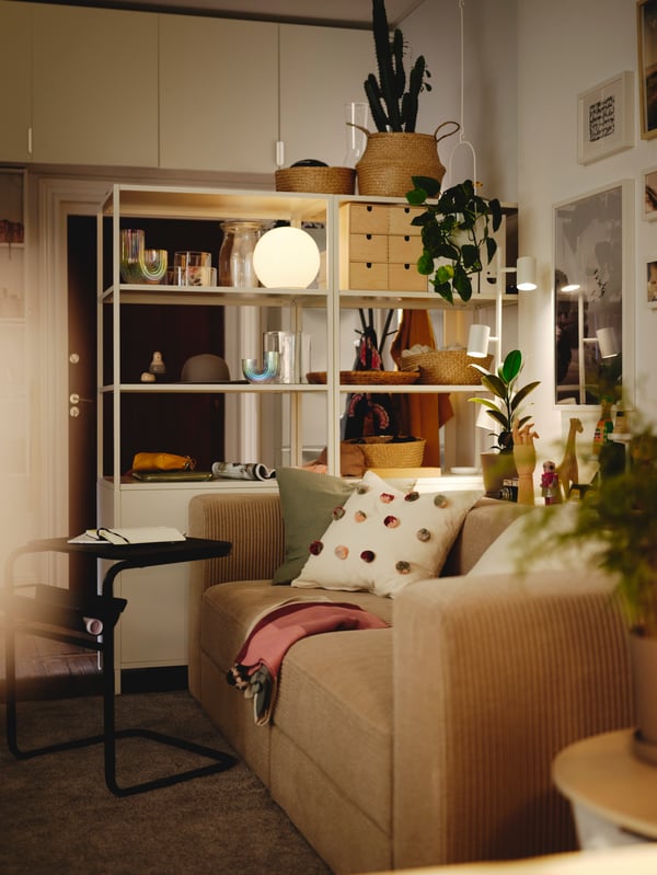A living area with two white TROTTEN cabinets with sliding doors next to a Samsala grey/beige JÄTTEBO 3-seat modular sofa.