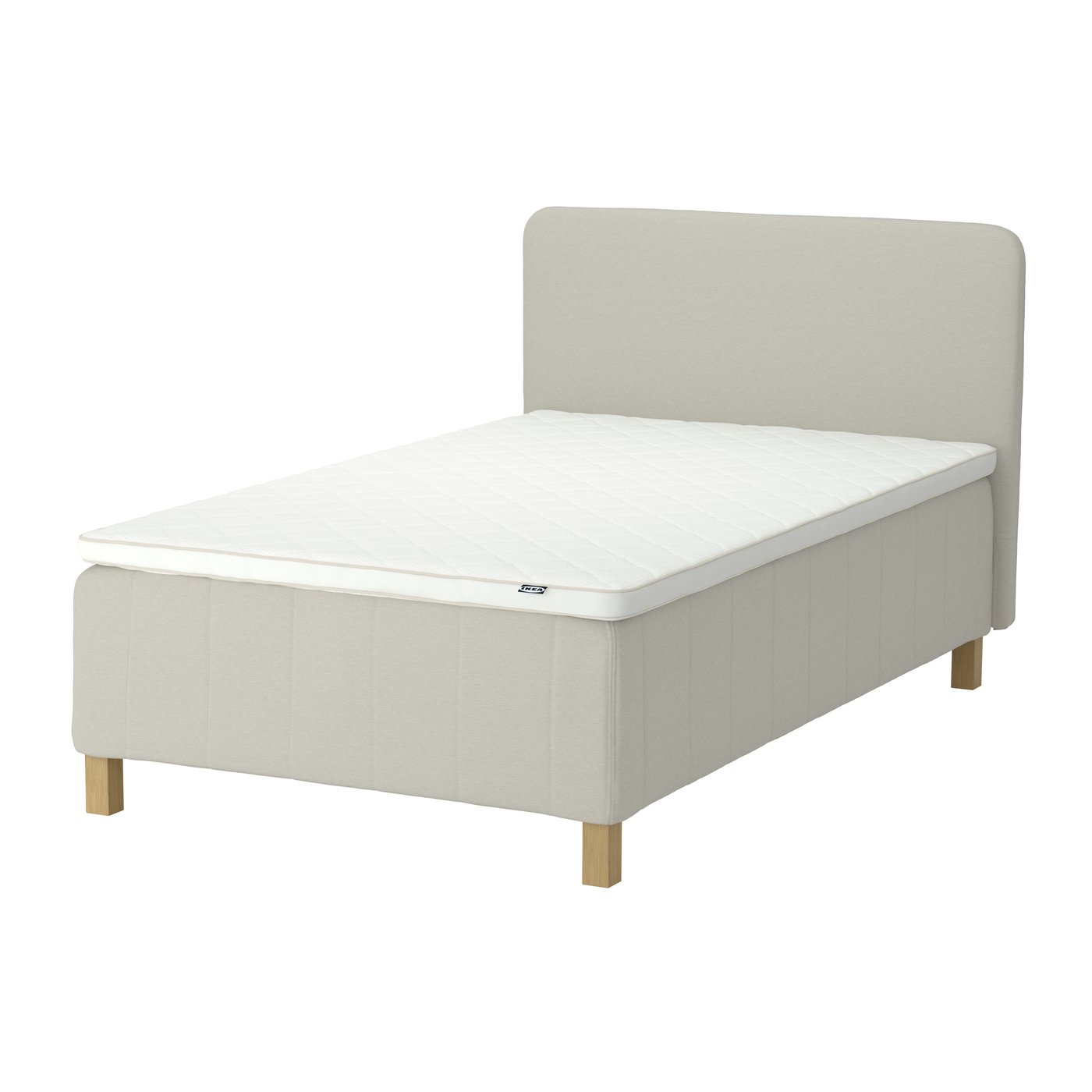 A beige RÅHOLMAR spring base bed with a headboard and a mattress topper on top.