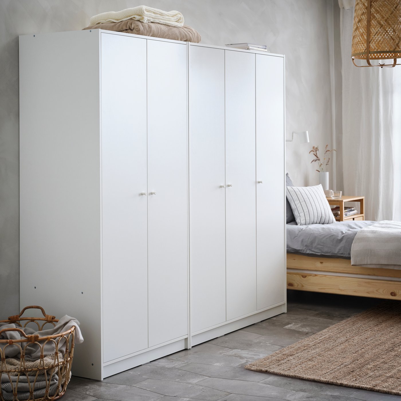 Two white KLEPPSTAD wardobes – one 2-door and one 3-door side by side next to a pine UTÅKER stackable bed in a white room.