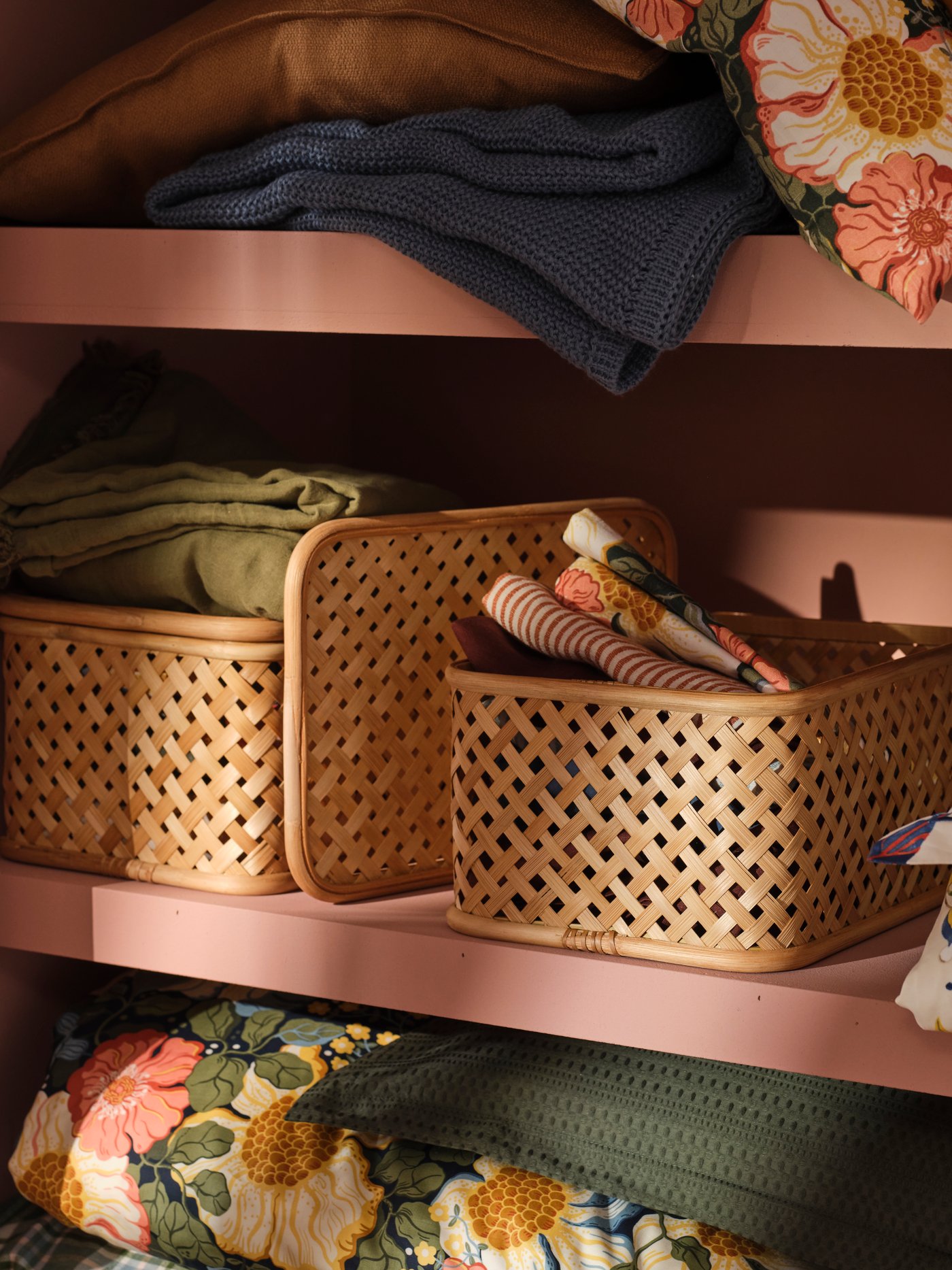 Beige VIELÅNGEN boxes in bamboo stand inside a pink wardrobe together with colourful bed linen.
Ideas to make space for everything – and everyone