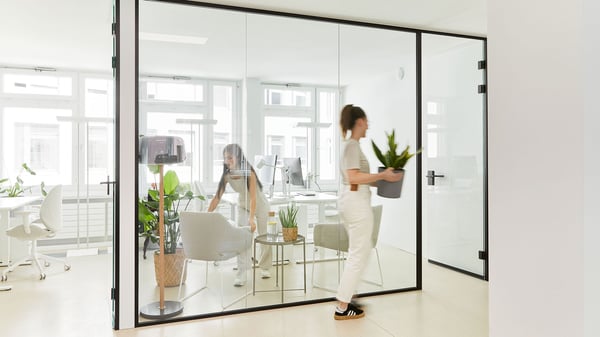 Ein Büroarbeitsplatz mit Schreibtisch, Büroshtuhl mit hoher Lehne und einem Büroregal mit Ablagemöglichkeiten für Dokumente