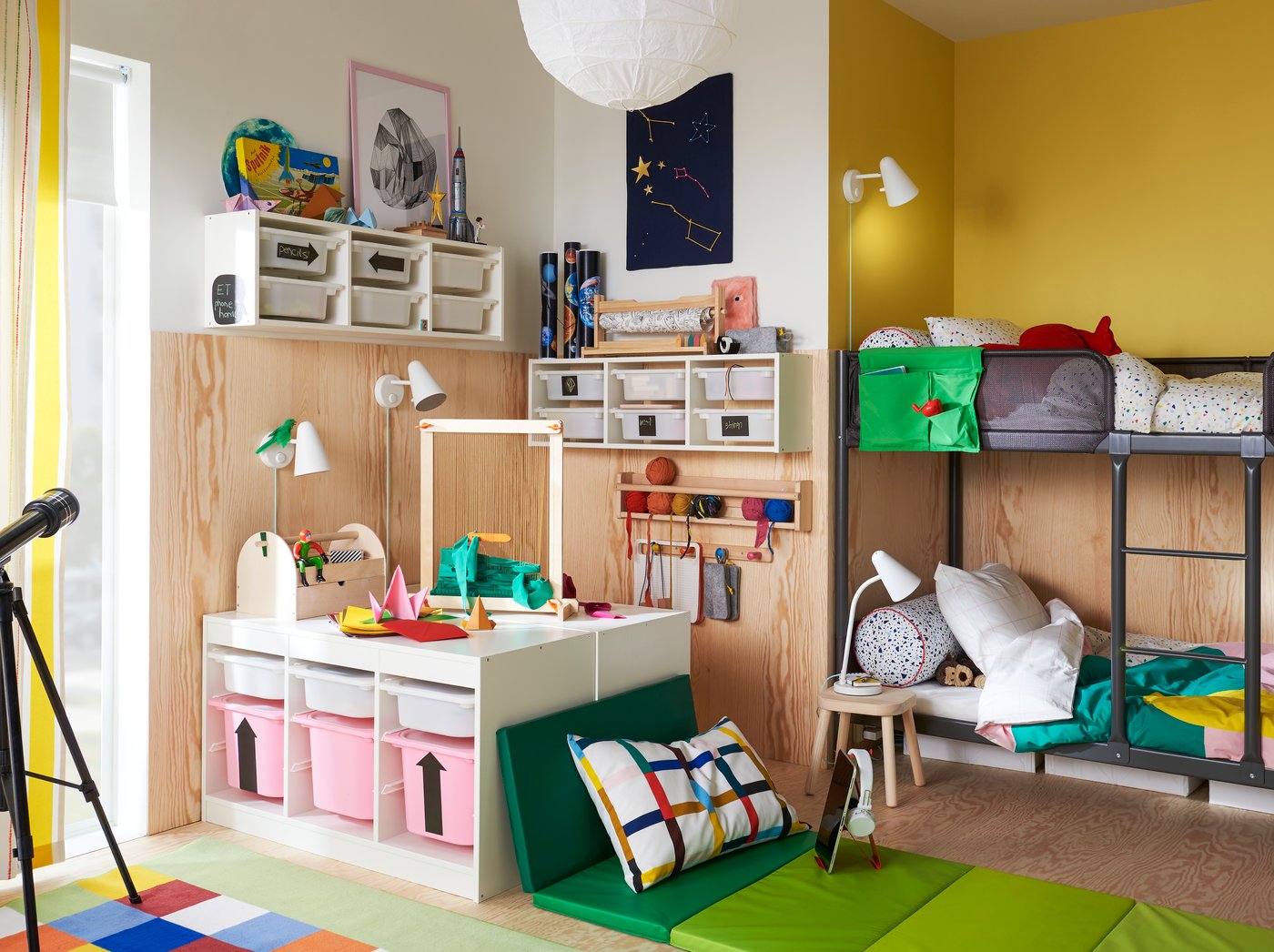 A child’s room with a TUFFING bunk bed, TROFAST storage and a soft seating area with a PLUFSIG folding gym mat.