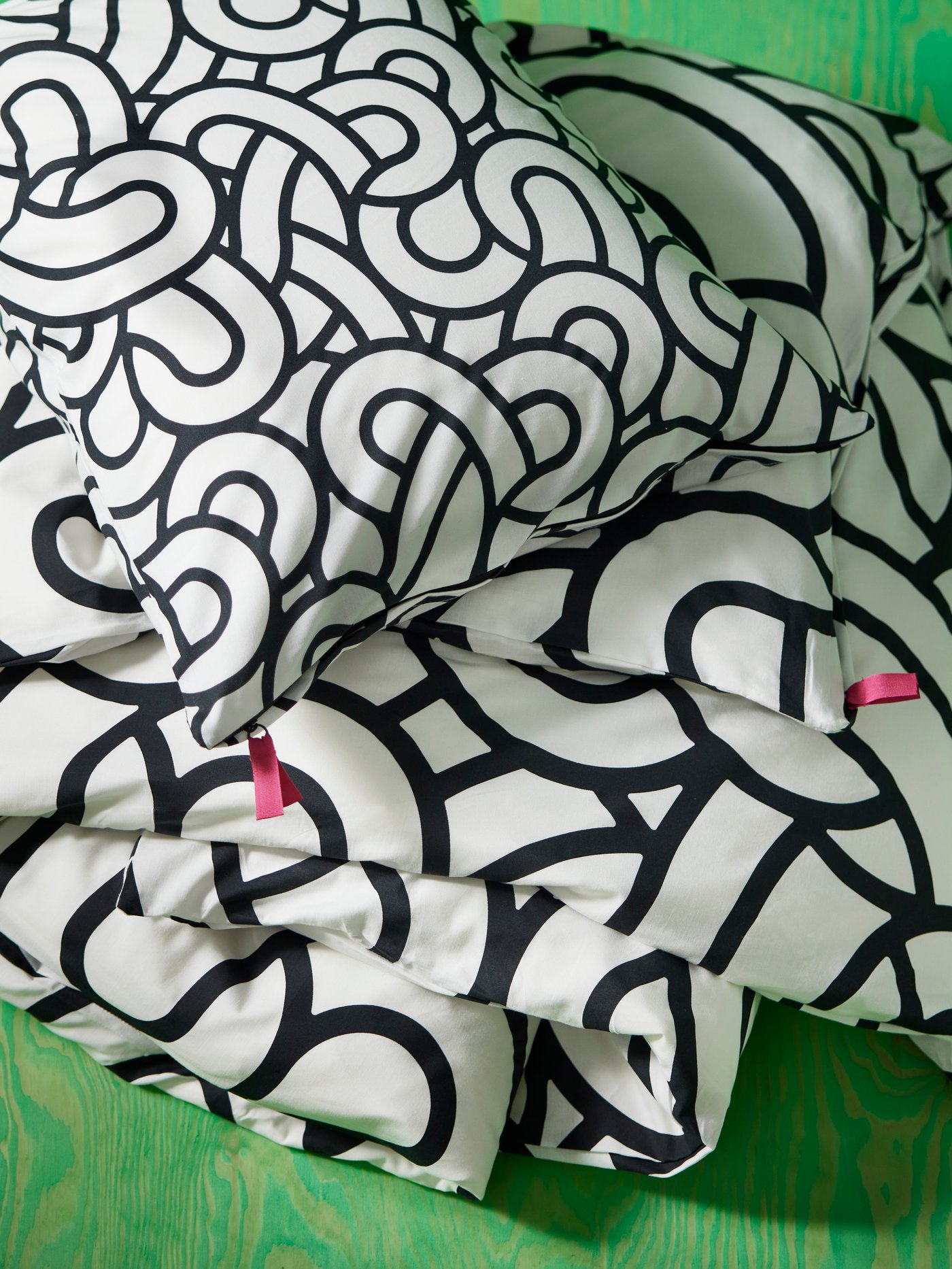 Duvet cover and pillowcase set from SÖTRÖNN collection in front of a bright green wall.