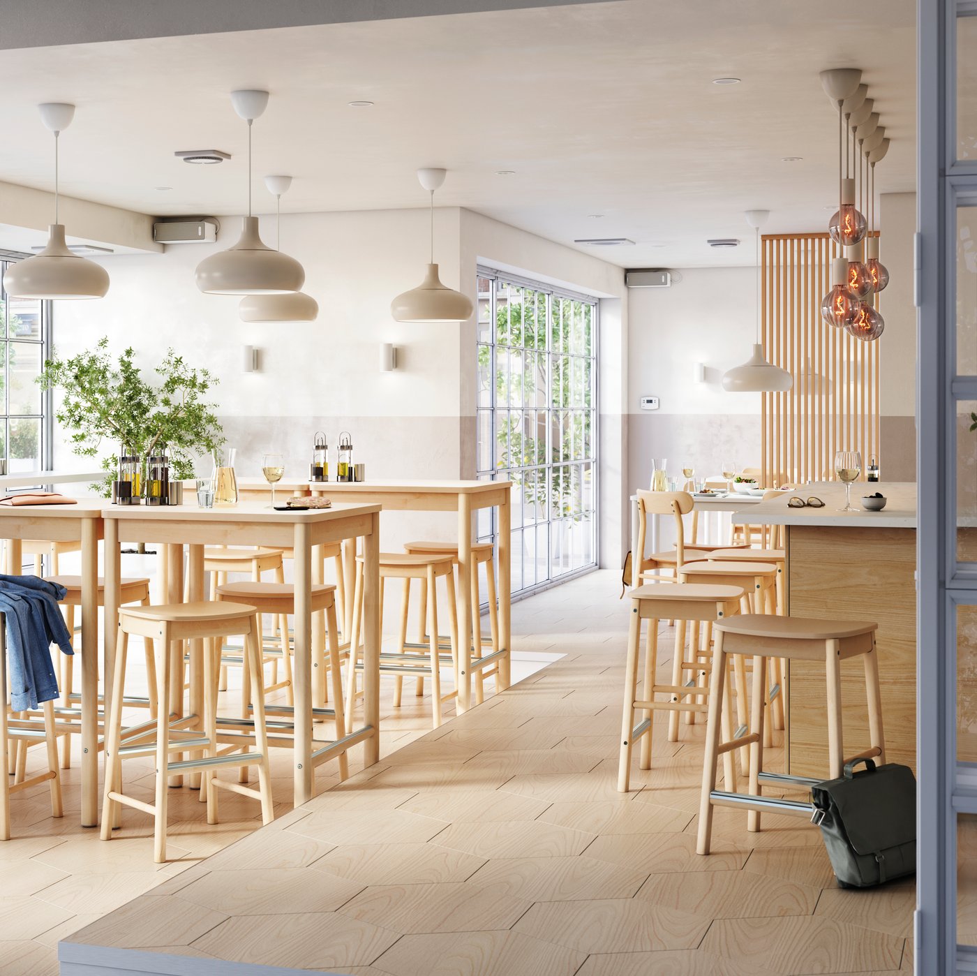 A bright and airy multi-zone bar with birch RÖNNINGE bar stools and tables by a window and seats at a bar in the center.