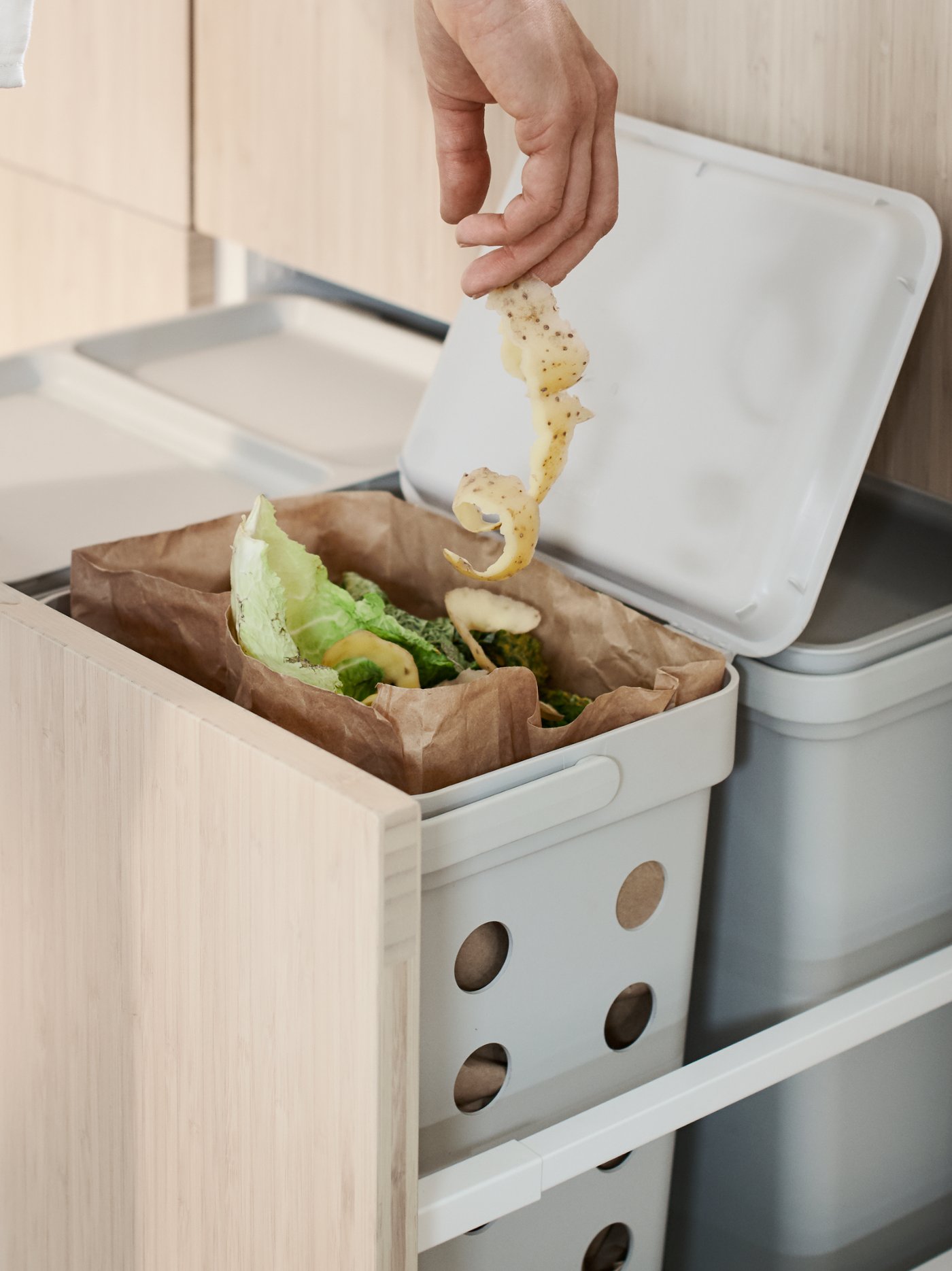 A light grey HÅLLBAR bin with lid in the kitchen