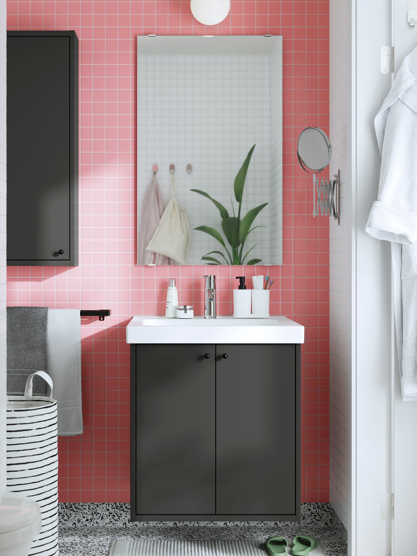 Ein Badezimmer Wandspiegel aus der Serie TOFTBYN über einem Waschbecken mit dunklem Unterschrank