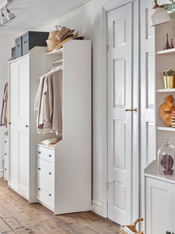 A high cabinet, a closed wardrobe and two open wardrobes from the HAUGA series create a matching look through two rooms.