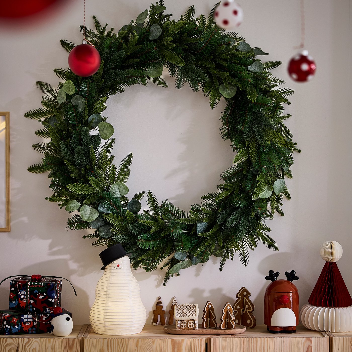 Una corona de navidad en un apared sobre un buffet 