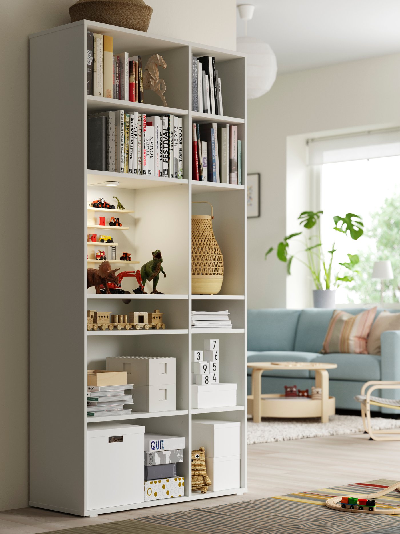 A white TJENA storage box with lid in a tall white shelving unit