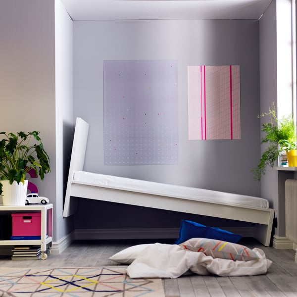 An IKEA bed tilting on a wall.