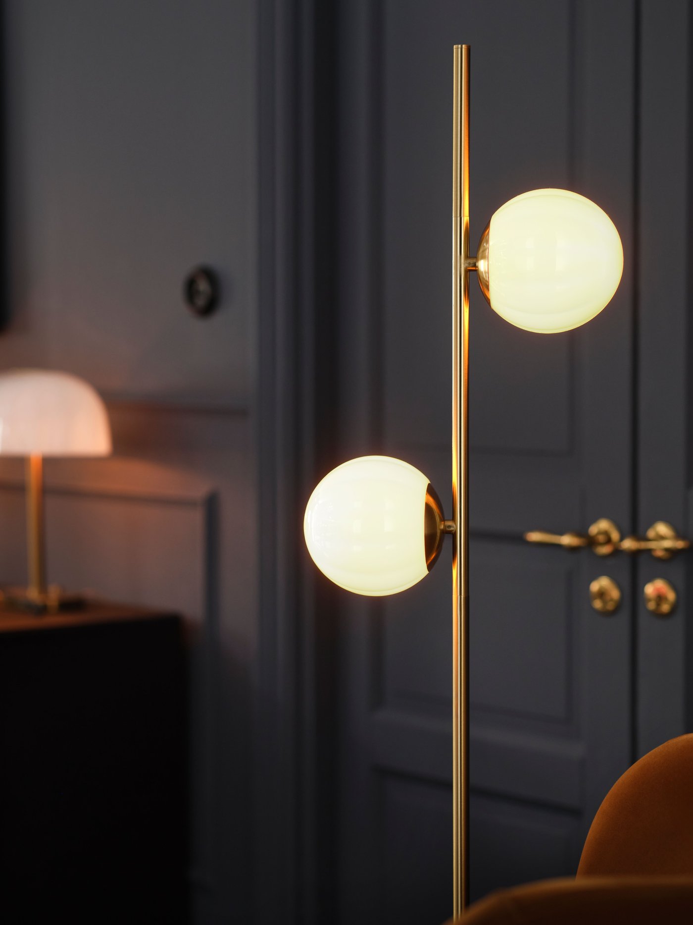 Stolní lampa AKTERSPRING z opálově bílého skla s mosazným pokovením v obývacím pokoji