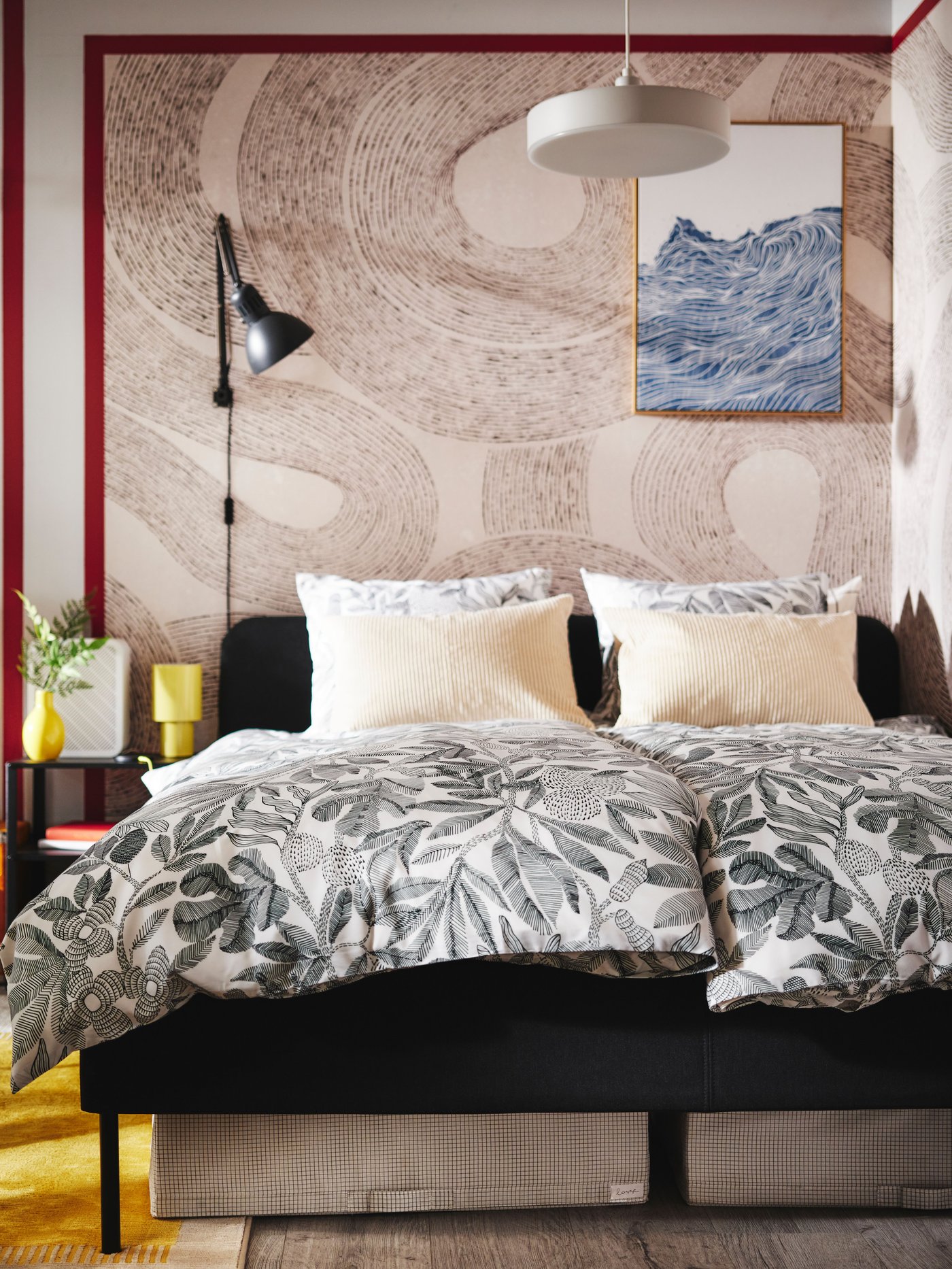 A white/black BROKDRACENA duvet cover and pillowcase on the dark grey SLATTUM bed in the bedroom.