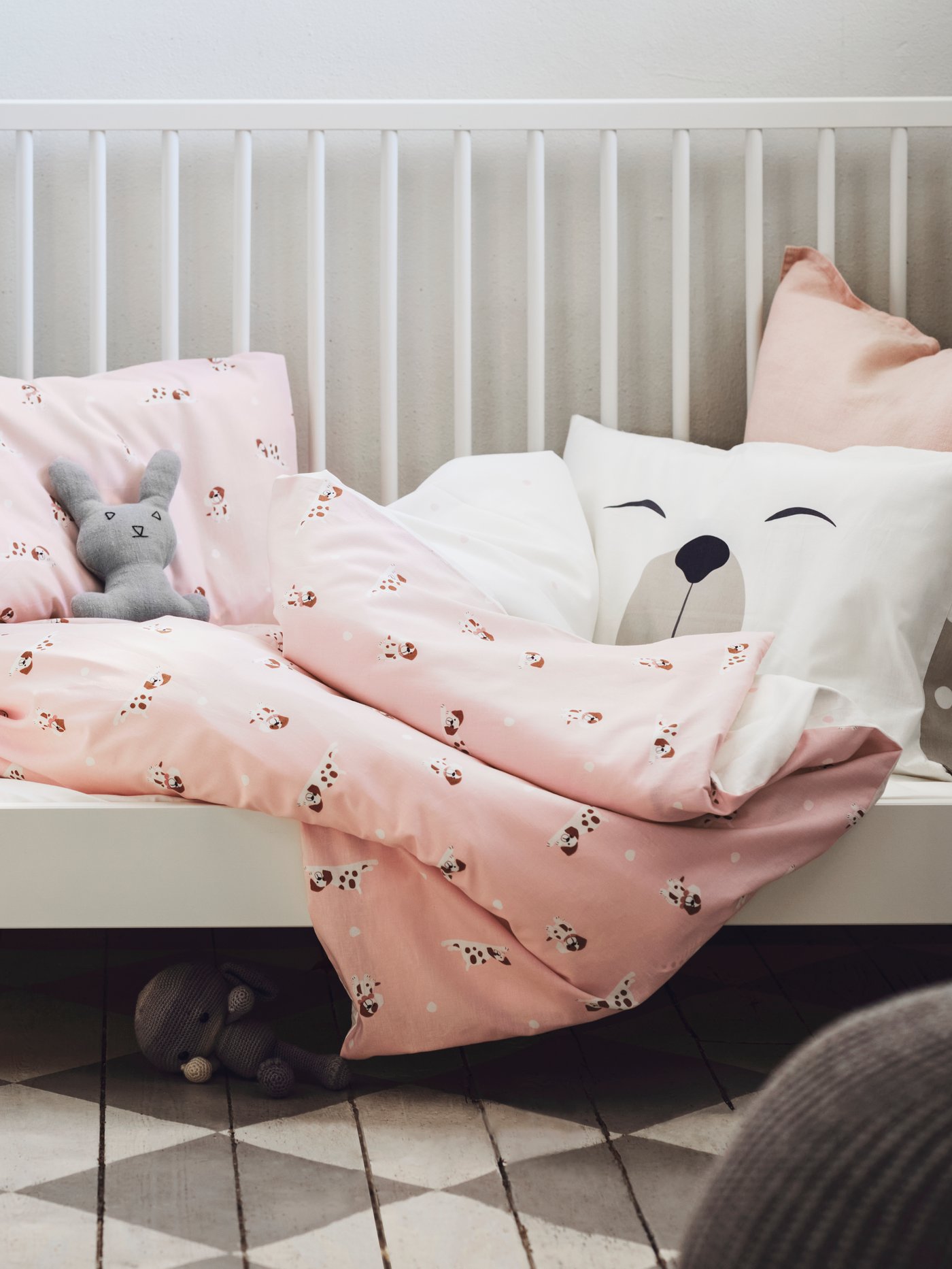 A DRÖMSLOTT baby bed linen hanging off a crib