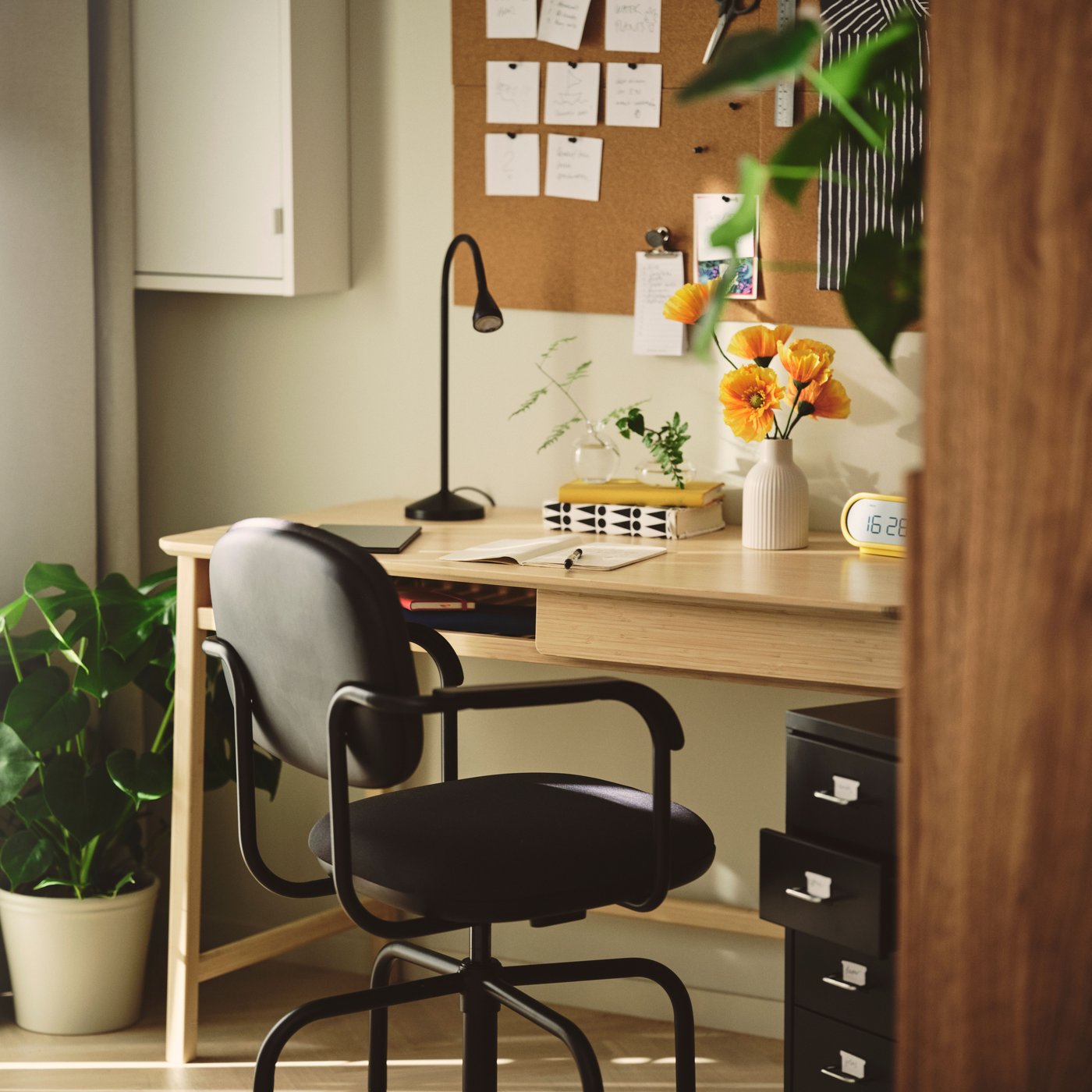 A white HAVBÄCK wall cabinet with door in the home office