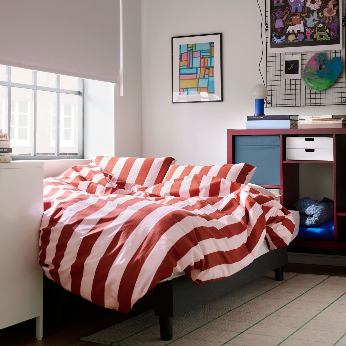A light pink dark red/stripe SLÅNHÖSTMAL duvet cover and 2 pillowcases in the bedroom