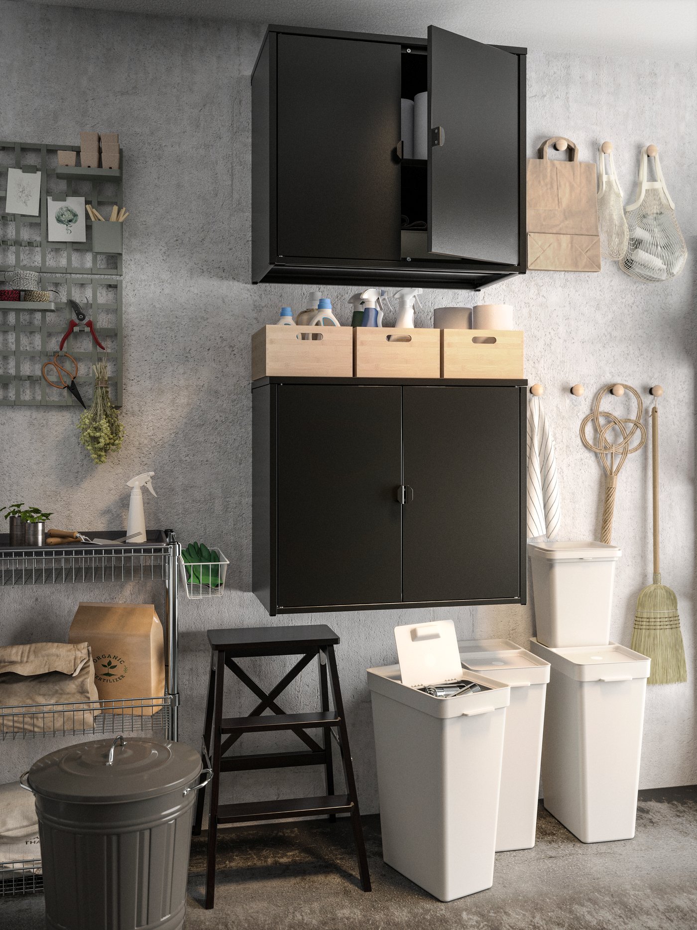 Closed black BROR cabinets are mounted onto the wall. HÅLLBAR recycling boxes are underneath next to a KNODD compost bin.