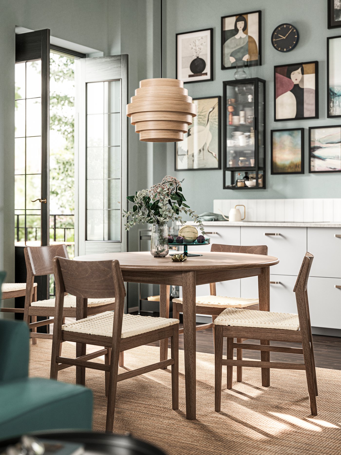 Quatre chaises SKANSNÄS en hêtre brun autour d’une table ronde à rallonge SKANSNÄS plaquée en hêtre brun sous une suspension DYKARKLOCKA.