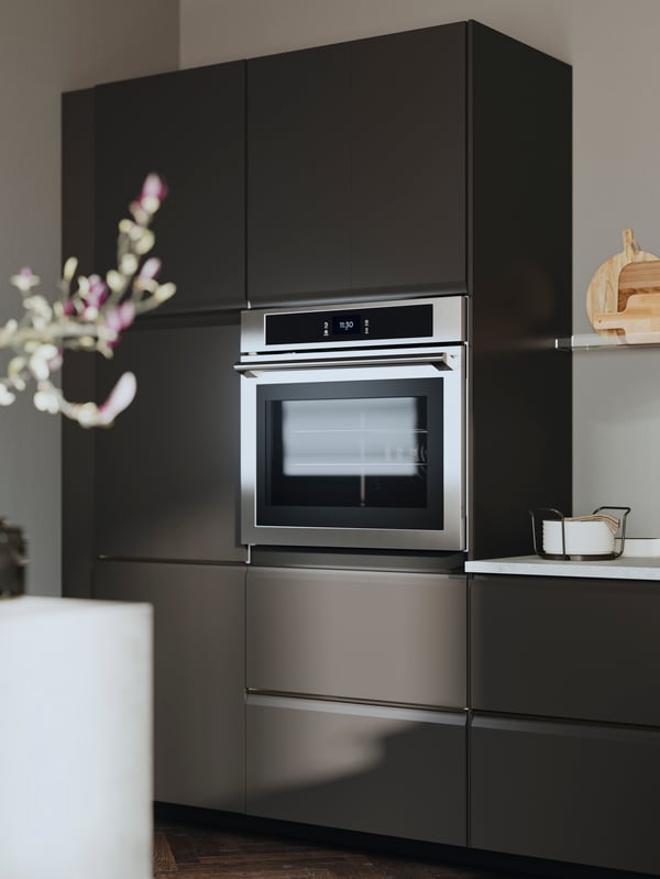A kitchen with UPPLÖV anthracite kitchen fronts, a MELLÖSA picture ledge and an TÄNGBY wall oven in stainless steel.