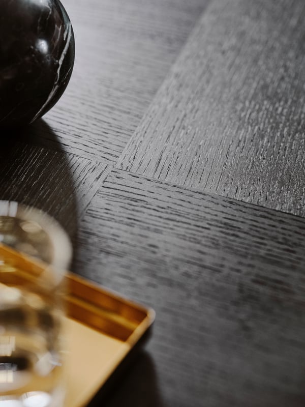 A close-up of the wood grain on the top surface of a dark brown oak veneer STOCKHOLM 2025 coffee table.