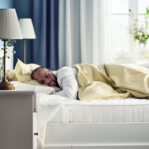An image showing a man on a bed sleeping on a VESTMARKA sprung mattress.