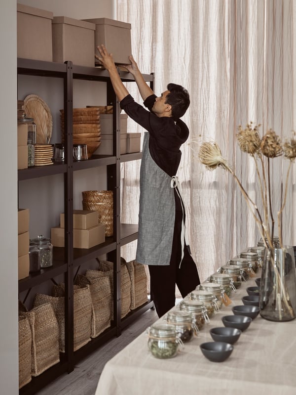 A man organizing in the shelves in a store.