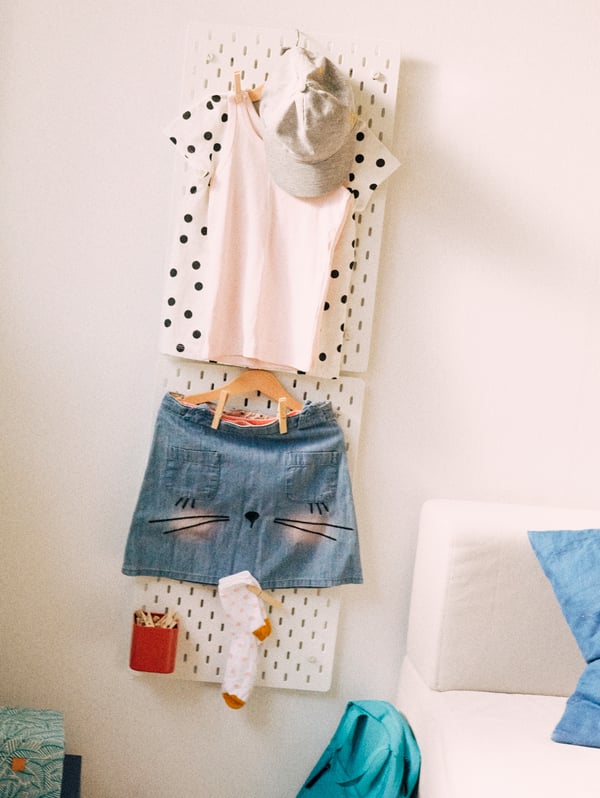 A SKÅDIS pegboard holds a schoolchild’s complete outfit ready for the next day – even her socks, school bag, and shoes.