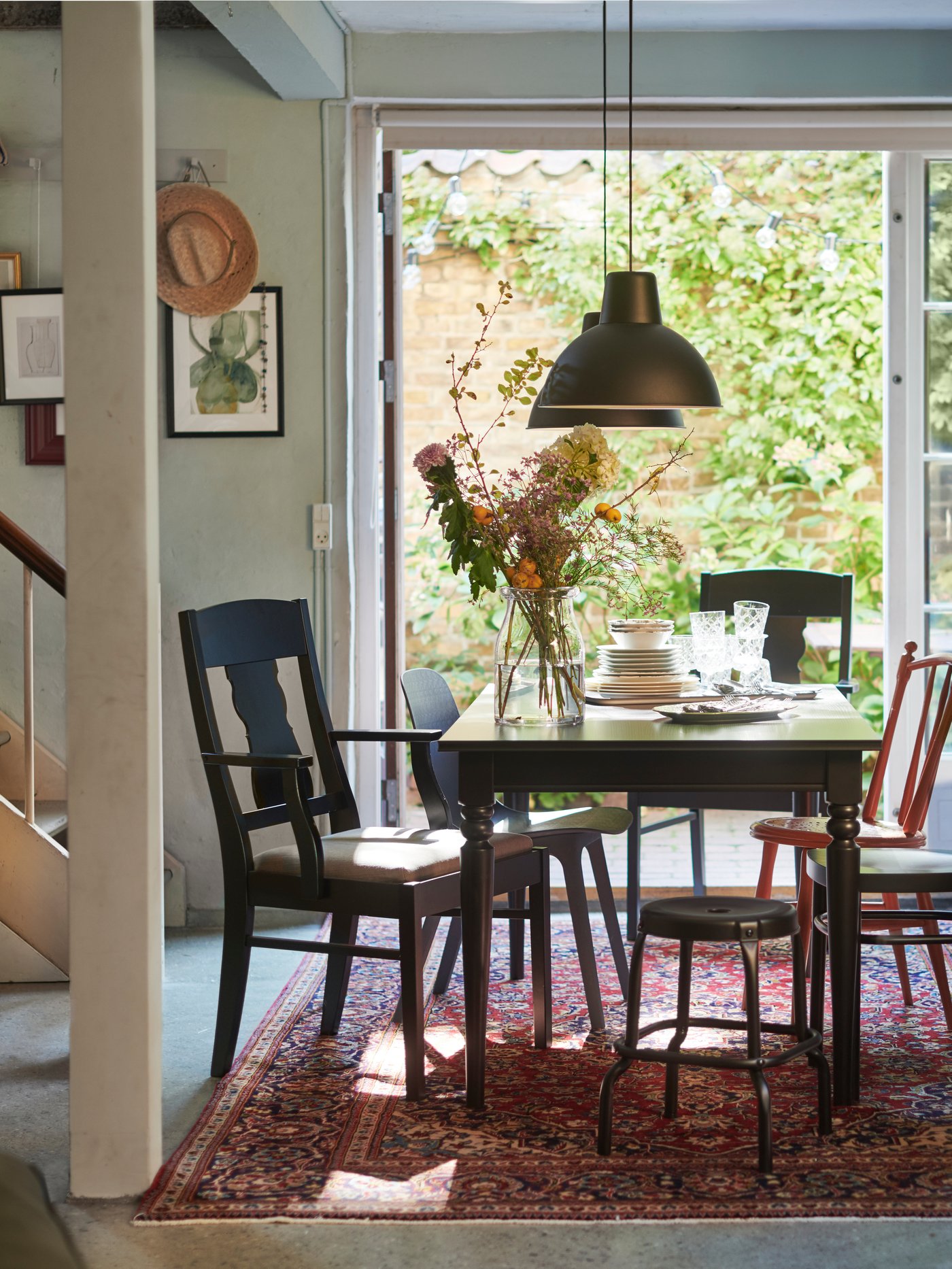 A black/Nolhaga grey-beige INGATORP chair with armrests in the dining room