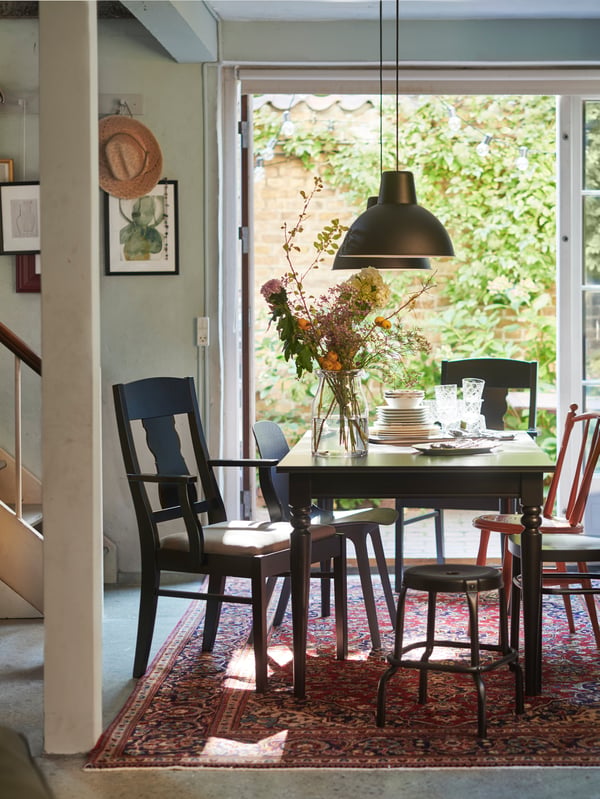 Juego de comedor INGATORP color negro, junto a une ventana.