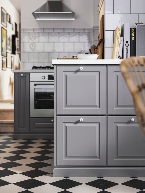 Base cabinets with grey BODBYN kitchen fronts, white/light grey stone effect/laminate worktops and a stainless-steel oven.