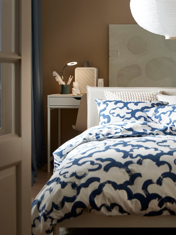 Una alcoba con una cama simple con una ropa de cama EKPURPURMAL con patrones azules.